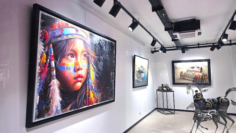 Plusieurs statues Orlinski de différentes tailles et couleurs, dans un espace d’exposition au design moderne.